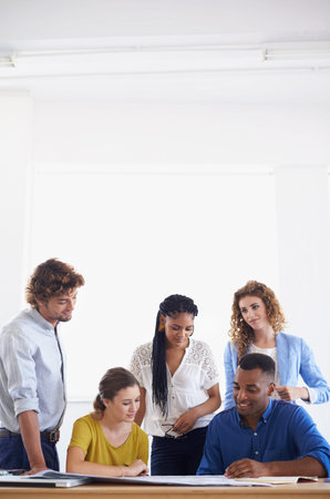 Young and creative minds hard at work. A group of young coworkers discussing work.