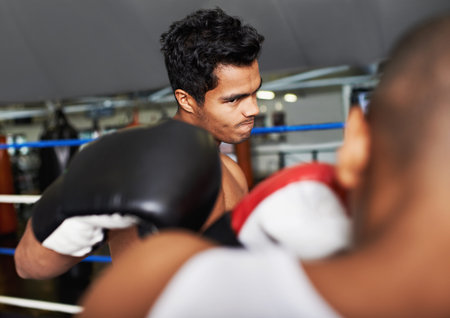 Coming at you full force. two young boxers sparring in a ring.