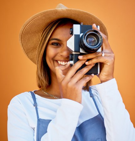 Portrait, photographer and black woman with camera, smile and creative against studio background. Face, African American female artist or lady with device, happiness or freelancer with casual clothesの写真素材