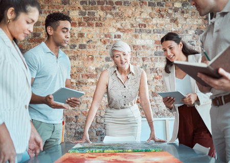 Team of art workers talking in meeting with painting, planning exhibition for creative strategy in gallery and working on design collaboration in office at work. Expert conversation about artworkの写真素材