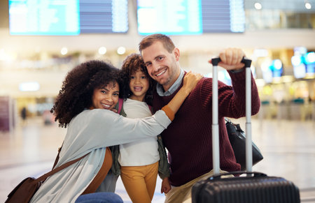 Happy, interracial and portrait of a family at the airport for travel, holiday and departure. Hug, smile and parents with a child, luggage and hugging affection on a vacation trip leaving togetherの写真素材
