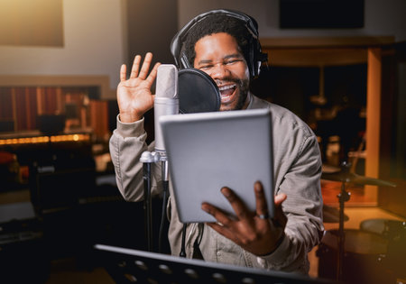 Tablet, music studio and man singing lyrics, song production or musician training for creative industry talent. Radio, microphone and audio of african person or singer voice on digital recording appの写真素材