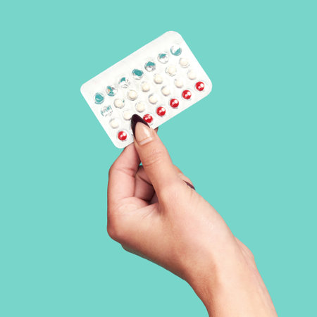 Woman hands, tablets and medication for birth control on mockup against a studio background. Hand of female holding contraception, healthcare product or medical prescription for market advertisingの写真素材