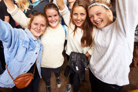 Excitement at the show. Portrait of young women enjoying an outdoor festival together.の写真素材