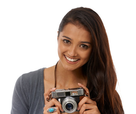 Say cheese. Cropped portrait of a young photographer holding a camera while against a white background.の写真素材
