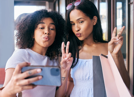 Selfie, peace and shopping with black woman friends posing for a phone photograph outdoor in the city together. Mobile, hand sign and pout with a female customer and friend in a mall or retail storeの写真素材