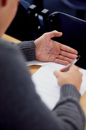 Theres no substitute for real studying...Over the shoulder shot of student cheating on an exam.の写真素材
