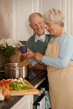 Shes making my lifetime favorite meal. an elderly couple preparing a meal together.の写真素材