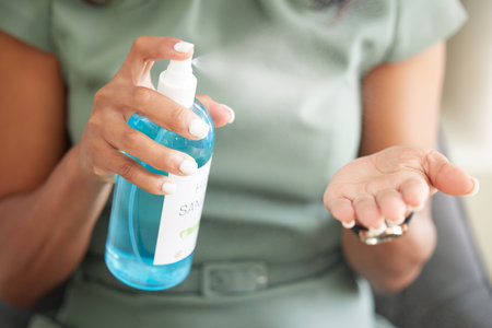 Sanitizer, hand and woman disinfecting for germs, bacteria or dirt in office for covid regulations. Virus, pandemic and professional employee sanitizing her hands for hygiene with antibacterial gel.の写真素材