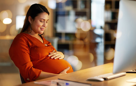 Pregnant, office and happy business woman on computer working late on project, website research and planning. Corporate, pregnancy and female worker happy, hope and excited for future baby at nightの写真素材