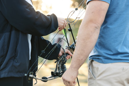 Shooting range, bow and archery sports training with a woman and man outdoor for target practice....