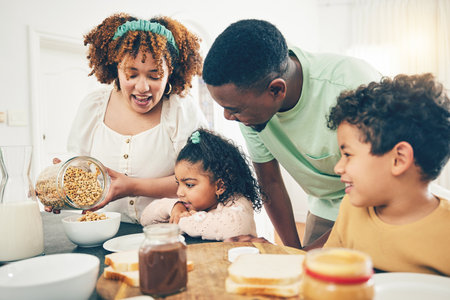 Breakfast food, black family and parent care with mother, dad and kids helping in the kitchen. Home, cereal and mama cooking with kids and father smile together with happiness in the morningの写真素材