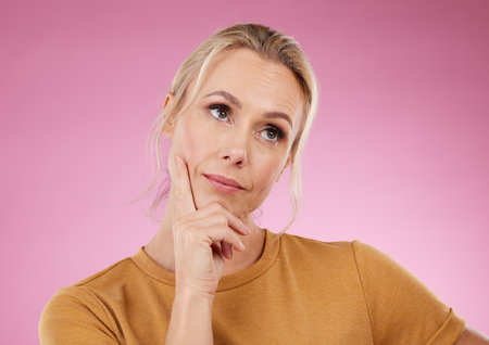 Thinking, woman and ideas on pink background, studio and color backdrop for mindset, planning or mockup. Inspiration, brainstorming and female model curious for question, solution and remember memoryの写真素材