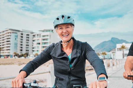 Mature woman, bike or helmet portrait for beach promenade cycling in wellness exercise, fitness or cardiology healthcare. Smile, happy or elderly person in bicycle head safety or eco friendly workoutの写真素材