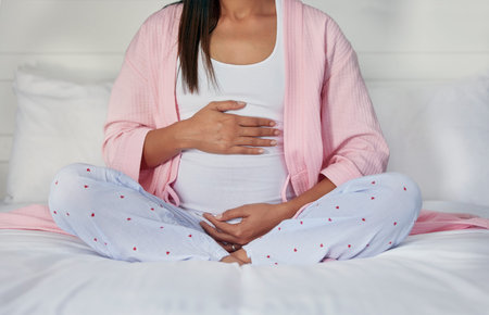 Pregnant, hands on stomach and woman in bed holding belly for baby, infant and affection at home....