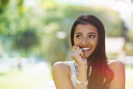 Bright smile on a sunny day. A young woman smiling while standing outside.