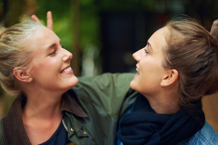Having a fun time. two young women having a good time at an outdoor festival.の写真素材