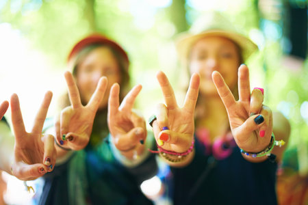 Peace, love and happiness. Three young woman wearing colourful nail polish showing a peace sign to the camera.の写真素材