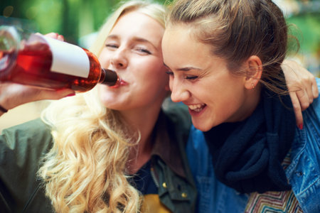 Rocking out at the festival. two young women drinking wine and having a good time at an outdoor...