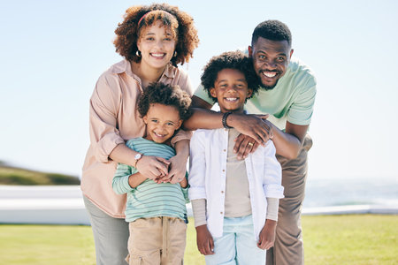 Love, happy and portrait of a family at the beach on a summer vacation, adventure or weekend trip. Happiness, smile and parents posing and bonding with boy children by the ocean while on holiday.の写真素材