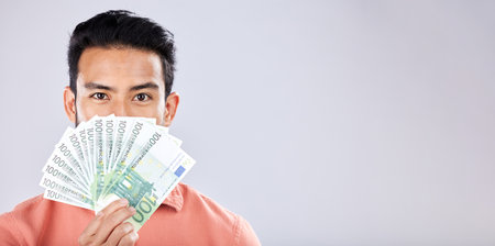 Man, portrait or money fan on isolated studio background in financial freedom, stock market profit or investment. Winner, cash or euro for asian person for finance success, savings or growth mockupの写真素材