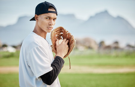Portrait pitcher, ready or baseball player training for a sports game on outdoor field stadium. Fitness, softball athlete or focused man pitching or throwing a ball with glove in workout or exerciseの写真素材