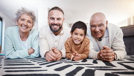 Happy, portrait and family on the floor for bonding, playing and quality time. Smile, happiness and father, child and grandparents lying on the living room during a visit together in a houseの写真素材