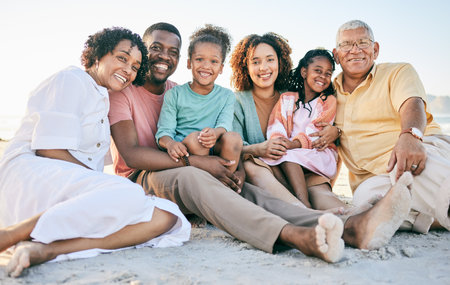 Family at beach, portrait and generations, happy people relax outdoor with grandparents, parents and kids. Happiness, smile and sitting together on sand, travel and vacation with love and bondの写真素材