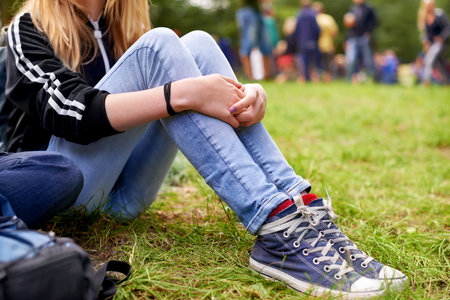 Time out on the turf. a woman sitting on the grass during a festival.の写真素材