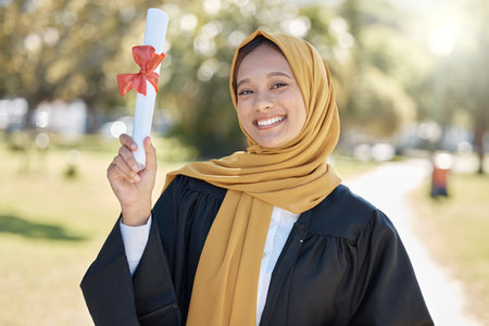 College graduation portrait of muslim woman with education certificate, learning success and university achievement. Islamic student or young hijab person and study diploma at campus, park or outdoorの写真素材