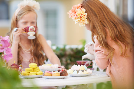 Having a make-believe tea party. Two young girls having a tea party in the backyard.の写真素材