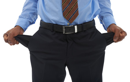 The credit crunch hits everyone. Cropped closeup shot of a businessman pulling out his empty pant pockets.の写真素材