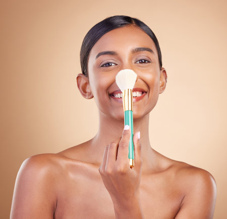 Portrait, nose and blush with a model woman in studio on a beige background to promote makeup. Face, blusher and product with an attractive young female posing for cosmetics or luxury wellnessの写真素材