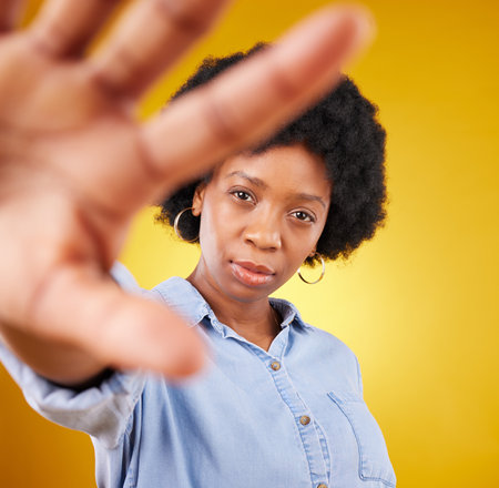 Portrait, beauty and selfie of black woman in studio isolated on a yellow background. Face, photographer or serious female or girl taking pictures or photo for profile picture, social media or memoryの写真素材