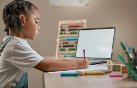 Girl writing, education toys and laptop in house with crayons, paper and mental development by desk. Young african child, female learner or pen for notes, drawing or learning in home school with pcの写真素材