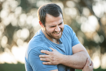 Man, fitness and injury or shoulder pain in park while running, exercise or training accident with...