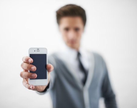 Presenting the newest smartphone. A young man holding his smartphone towards the camera.の写真素材
