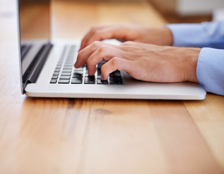 Hard work brings rewards. Cropped image of a business working on his laptop.の写真素材