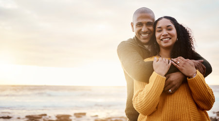 Hug, happy and portrait of a couple at the beach for a date, bonding or sunset in Bali. Love, embrace and young man and woman smiling while relaxing at the ocean for vacation with mockup spaceの写真素材