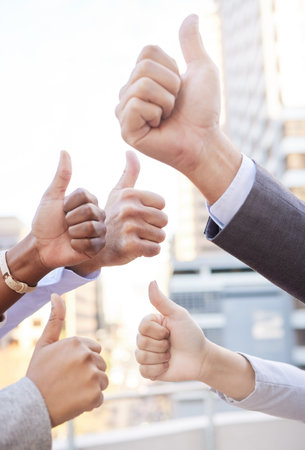 The symbol of success. an unrecognisable group of businesspeople standing together outside and showing a thumbs up.の写真素材
