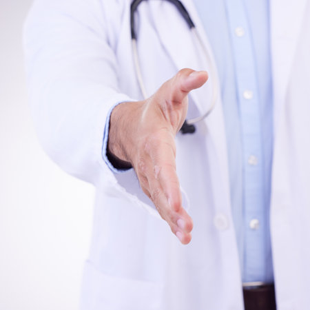 Doctor, man and handshake for healthcare partnership, meeting or greeting against a white studio background. Hand of isolated male medical professional shaking hands for introduction or thank youの写真素材