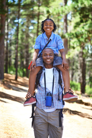 Building a love of the outdoors together. Happy african father and son spending time in the woods together.の写真素材