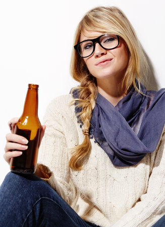 Just chillin with a cold one. Portrait of a beautiful young woman relaxing with a beer.の写真素材