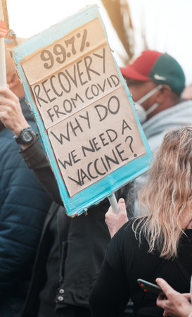 Stop inflating the numbers for your own benefit. Cape Town, South African - October 2, 2021 Unrecognisable demonstrators holding up signs and protesting against the Covid 19 vaccine.の写真素材