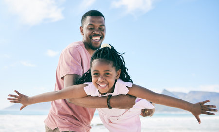 Child, black man and airplane game on beach on playful family holiday in Australia with freedom and energy. Travel, fun and happy father and girl with smile playing and bonding together on vacation.の写真素材