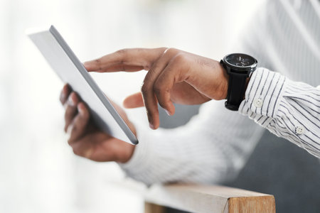 Choose to do business the smart way. Closeup shot of an unrecognisable businessman using a digital tablet in an office.の写真素材