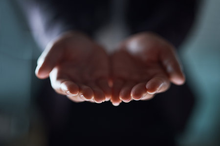 No one has ever become poor by giving. an unrecognizable businessman standing with his hands cupped together.の写真素材