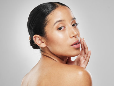A glow so good Ive become addicted. Studio portrait of an attractive young woman posing against a grey background.の写真素材