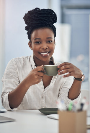 A cup of coffee makes my workday better. a businesswoman enjoying a cup of coffee at work.の写真素材