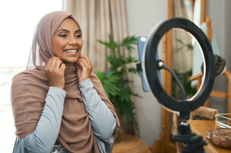 This is my side hustle. a young muslim female busy recording her for her vlog.の写真素材